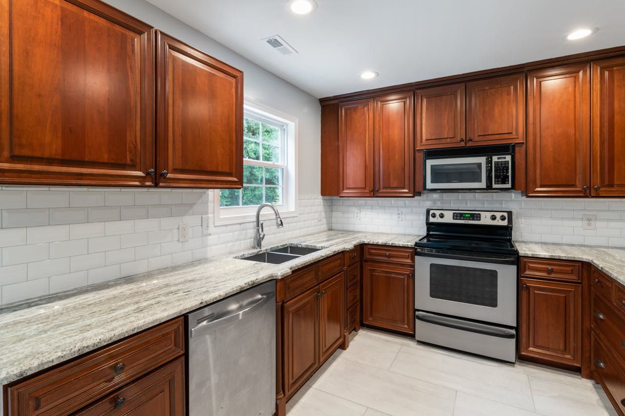 Spacious kitchen with wooden cabinets, modern appliances, and granite countertops.